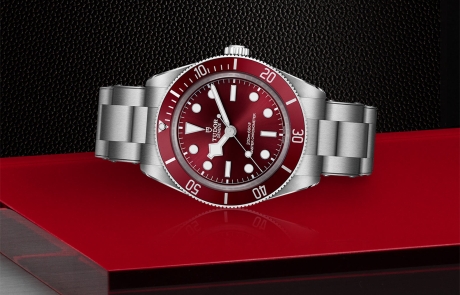 TUDOR BLACK BAY 58 laid down showcasing the burgundy, domed, with applied hour markers dial and overall elegance.