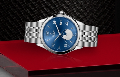 TUDOR 1926 laid down showcasing the blue satin sun-brushed dial with applied numerals and moon phase indicator dial and overall elegance.