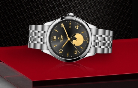 TUDOR 1926 laid down showcasing the black satin sun-brushed dial with applied numerals and moon phase indicator dial and overall elegance.